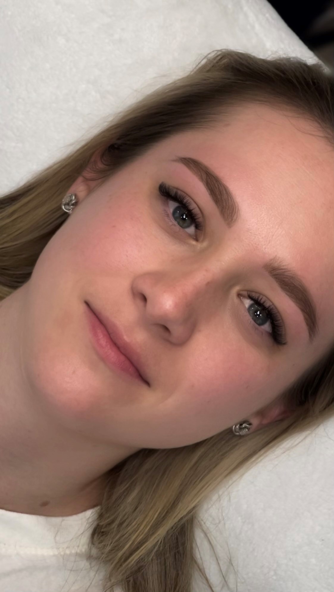 Young blonde woman showing her brows after receiving brow services